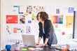 © Guille Faingold/Stocksy - Businesswoman stand at desk in office.