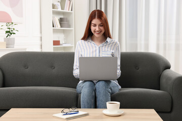 Poster - Happy woman using laptop on couch in room