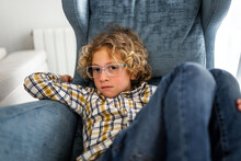 Boy Sitting On The Sofa At Home