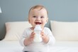 cute happy little baby holding a feeding bottle with milk and smiling. Milk formula for babies