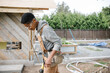 © Rob and Julia Campbell/Stocksy - Carpenter working on the jobsite with tool belt.