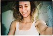 © Asya Molochkova/Stocksy - Selfie on film camera of smiling woman in the morning