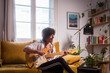 © Ibai Acevedo/Stocksy - Singing and playing guitar with joy at home