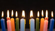 © María Soledad Kubat/Stocksy - Group of colorful candles burning in the dark