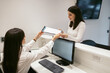 © Pedro Merino/Stocksy - Young woman signing a patient form in a clinic