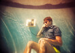© Ibai Acevedo/Stocksy - Surreal portrait of man using phone underwater