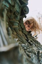 Girl Peeking Out From Behind A Lamppost