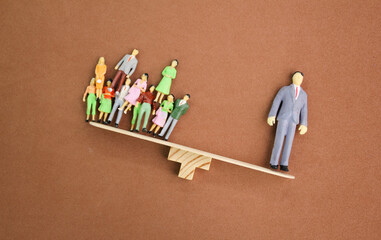 the balance of miniature people workers and leaders. the leader is heavier. leaders are more valuable and good. High skill worker and talent concept.