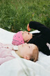 © Irina Bo/Stocksy - sisters lie on a blanket on the grass