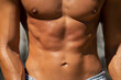 © Sonja Lekovic/Stocksy - male naked and tanned torso and abs closeup