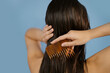 © Artem Podrez/Stocksy - Woman brushing wet hair with comb.