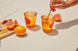 © Joe St.Pierre/Stocksy - Women Stirs Blood Orange Cocktail
