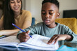 © Pedro Merino/Stocksy - Close-up of a little boy doing homework at home