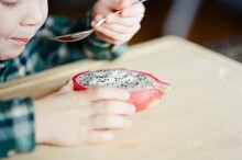 Little Cute Toddler Boy Eating Dragon Fruit With Spoon Independently 