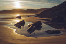 Sunset On A Sandy Beach With Rock Pools