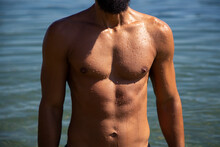 Male Tanned Torso And Blue Water Background