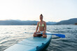 © Marko/Stocksy - Woman on SUP paddle board