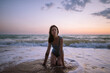 © Alina Miluseva/Stocksy - Beautiful Woman In Sea Waves On Beach At Twilight