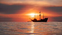 Orange Sunset  With
Old Historical Tall Ship (yacht) In Sea.