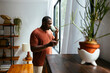 © BONNINSTUDIO/Stocksy - Man using phone at morning at home