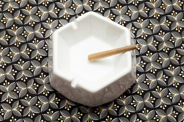 Cannabis preroll in ceramic ashtray on patterned background