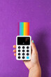 © Shava Cueva/Stocksy - A woman's hand holding a wireless terminal with a credit card in