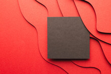 Square Of Black Paper With Copy Space On Red Waves Of Paper On Red Background
