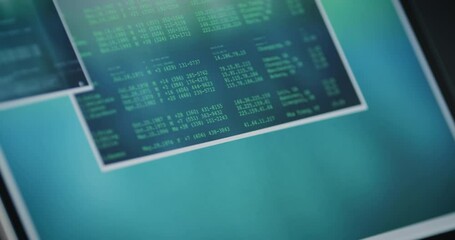 slow tracking shot over tablet screen with various data windows and programming in partly binary cod