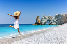 A Happy Tourist Woman In A White Summer Dress Enjoys The Beautiful Beach Of Lalaria, Skiathos Island, Greece