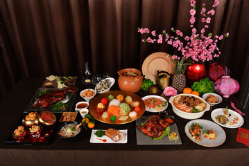 Wall Mural - chinese new year festival asian food cuisine with meat, vegetable, noodle, cookies and yusheng lo hei with sakura flower lantern decoration on bronze background restaurant banquet halal dining menu