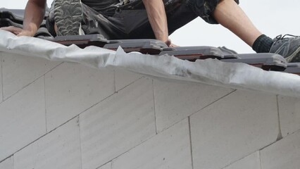 Wall Mural - contractor builder laying fired ceramic tiles on the roof