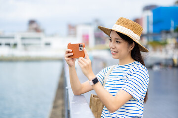 Poster - Woman use cellphone to take photo in Keelung harbor