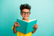 © deagreez - Photo of diligent nice schoolboy with brown hair dressed yellow t-shirt holding book read story isolated on turquoise color background