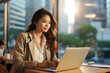 © Planetz - Young Asian business woman a professional marketing sales manager using laptop with city view in day time