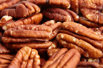 Wall Mural - Pecan nuts kernel texture background closeup. Heap of peeled pecan halves. Pecan halves, a puzzle of nutty goodness