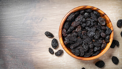 Poster - Black raisins in wooden bowl, top view. Healthy snack, dietary product for good life