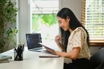 Young female programmer freelancer coding scripts java language, checking database while working at home.