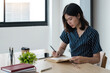 © Natee Meepian - Young attractive university student take note, Asian woman writes notes, planning working process, sitting at classroom. Exam preparation