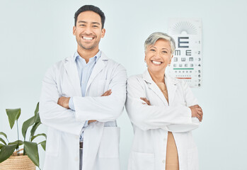 Canvas Print - Doctors, optometry and arms crossed, portrait and eye care with vision, help and optometrist team at clinic. Wellness, health and support, collaboration and confidence with Asian man and senior woman