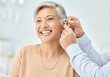© Ilzer/peopleimages.com - Senior patient, hearing aid and doctor hands, ear and listening, help and trust, healthcare and medicine. Medical tech, consultation with ENT specialist and health, happy woman and people at clinic