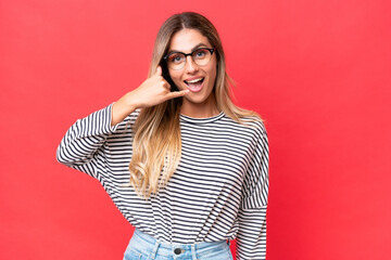 Wall Mural - Young Uruguayan woman isolated on red background making phone gesture. Call me back sign