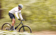 © D Theron/peopleimages.com - Nature mockup, bicycle or sports man travel, ride and journey on freedom adventure, extreme triathlon race or cycling. Mountain bike, forest speed blur and athlete training for competition in woods
