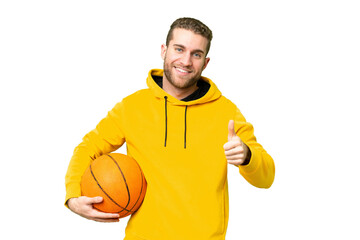 Wall Mural - Young handsome blonde man over isolated chroma key background playing basketball and with thumb up