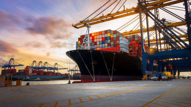 Crane loading Cargo Container export container ship in the international terminal logistics sea port concept freight shipping by ship, Truck running in port under the Big Crane transport trade