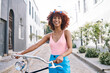 © Wesley/peopleimages.com - Bicycle, gen z or portrait of happy woman cycling with street fashion in urban outdoor activity on holiday. Excited city girl, streetwear or sustainable transport for trip or travel on bike in road