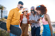 © Wesley/peopleimages.com - People, phone and friends laughing outdoor for meme, funny video and fun. Diversity, happiness and gen z group of men and women with a smartphone for social media, skateboard and freedom in city