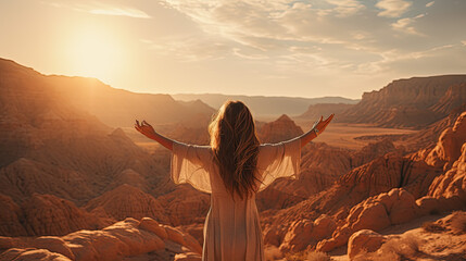 Poster - a young pretty woman with long hair stretches her arms up to the sides in front of a desert and looks into the distance.