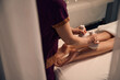 Massotherapist giving her client hot compress leg massage
