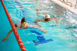 Interracial swimmers practicing breaststroke technique in water