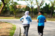 © Hardollin - Young muslim couple happy together running at green summer park. Man and woman in hijab doing morning workout outdoors.
